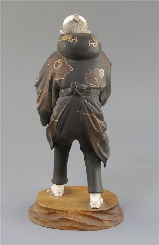 A Japanese lacquer and ivory okimono of a man, Taisho period, 1920s, H. 29cm, parts lacking